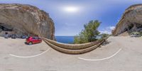 the car is parked near a giant stone structure in the desert of the cliff face it