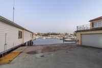 this house is on the water looking down to a boat dock near some houses and a harbor