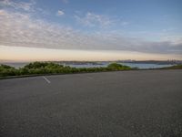 an empty parking lot with a city in the background during sunset or sunset time,