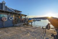 the dock in front of a small fishing hut with many boats out on water near it