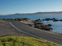 an image of a beautiful beach and coastline road from a hill side perspective at sunset