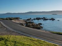 an image of a beautiful beach and coastline road from a hill side perspective at sunset