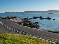 an image of a beautiful beach and coastline road from a hill side perspective at sunset