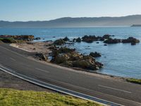 an image of a beautiful beach and coastline road from a hill side perspective at sunset