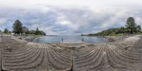 this is an oval mirror view of the water and rocks along with the road and beach