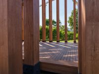 an open door on a wooden deck overlooking the green landscape and trees in the distance