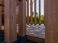 an open door on a wooden deck overlooking the green landscape and trees in the distance