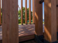 an open door on a wooden deck overlooking the green landscape and trees in the distance