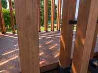 an open door on a wooden deck overlooking the green landscape and trees in the distance