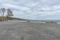 this parking lot has a bench along side the lake and sea with a view in the distance