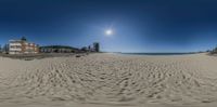 a fisheye lens photo of a beach side hotel with sun glaring on it's horizon