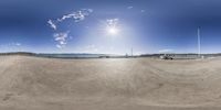 a view through a fisheye lens of a beach with a boat and pier on the water