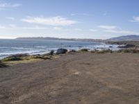 a beach is next to a road, overlooking the ocean and an ocean side cliff