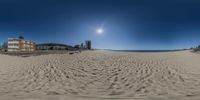 a fisheye lens photo of a beach side hotel with sun glaring on it's horizon