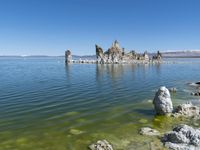 an empty lake filled with rocks and boulders near a barren shore line of water in a desert