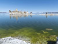 an empty lake filled with rocks and boulders near a barren shore line of water in a desert