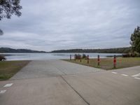 a paved area next to a river on a cloudy day with no clouds on the water