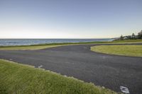 a paved path that stretches into the ocean from the ocean shore at dawn in a residential area