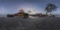 a fish - eye view of a dock with buildings on it at sunset and water flowing under