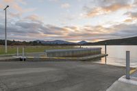 a parking dock and water reservoir on a lake with mountains in the distance during sunset