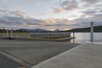 a parking dock and water reservoir on a lake with mountains in the distance during sunset