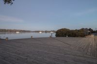 the wooden boardwalk next to the lake is very long in length and stretches across the area