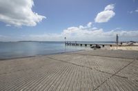 a small boat is docked at the pier in this picture and a sky with white clouds