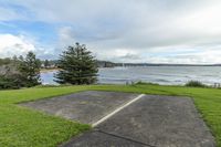 the empty parking lot is beside a body of water on a hill overlooking the ocean