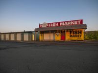 a fish market store with signs advertising fish market in front of it and a yellow fire hydrant sitting in front