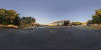 a 360 - degree photo shows an intersection on a dirt road with a few trees