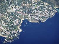 an aerial view of an island and some boats out in the water, some trees on the shore