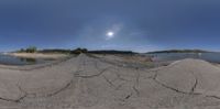 a lake with some rocks in front of it and a sky with clouds overhead it is an image that appears to be fish eye