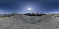 a wide angle fish - eye view of a beach and water from behind the rocks