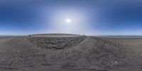 this is a 360 view of some people riding skateboard around the big hill at beach