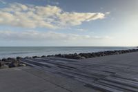 a walkway on the side of a body of water leading to an ocean on a sunny day