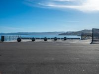 four spheres placed in a row on the street, with a view of mountains in the background