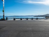 four spheres placed in a row on the street, with a view of mountains in the background