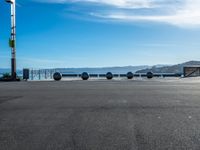 four spheres placed in a row on the street, with a view of mountains in the background