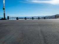 four spheres placed in a row on the street, with a view of mountains in the background