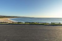 there is a parking lot next to an ocean beach with a person riding on it