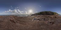 the ocean in a circular motion shot near a small island and sand covered shore line