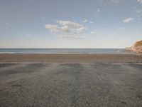 empty parking lot with open water and sea view in background at beach in early fall