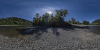 a pond with many rocks that have fallen on them near the shore and trees around it