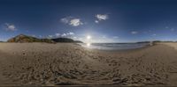 a 3d beach scene with blue sky, ocean and sand ripplers below clouds, and the sun setting on a rocky shore