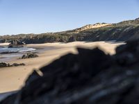 an image of the coast with a black rocks in front of it and water behind