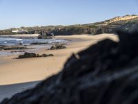 an image of the coast with a black rocks in front of it and water behind