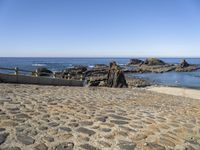 an old beach on the shores of the ocean with a stone path leading to rocks and water