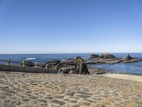 an old beach on the shores of the ocean with a stone path leading to rocks and water