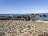 an old beach on the shores of the ocean with a stone path leading to rocks and water