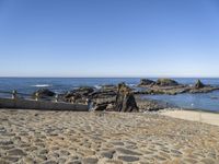 an old beach on the shores of the ocean with a stone path leading to rocks and water